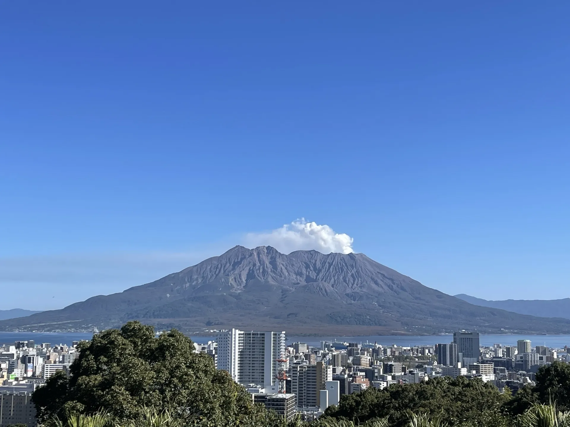 噴煙を上げる桜島と鹿児島市の市街地